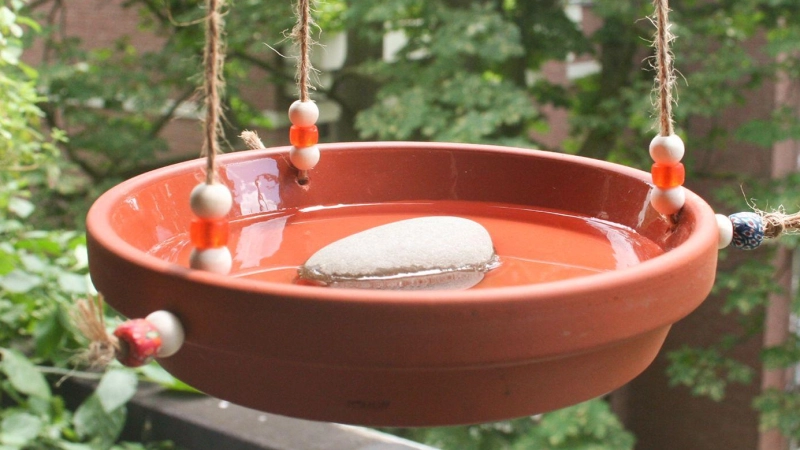 Drei Löcher, ein paar Schnüre: So wird aus einem Tonuntersetzer eine nützliche Trinkstelle für Vögel. (Foto: Steffen Rieger/DIY Academy e.V./dpa-tmn)