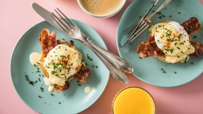 Wie ein Schuss flüssiges Gold fließt die Hollandaise bei Eggs Benedict über pochierte Eier auf Bacon und halbierten englischen Muffins. (Foto: Christin Klose/dpa-tmn)