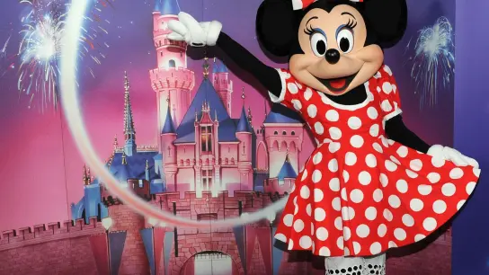 Minnie Maus vor dem Logo der Walt Disney Company. (Foto: Ursula Düren/dpa/Archivbild)
