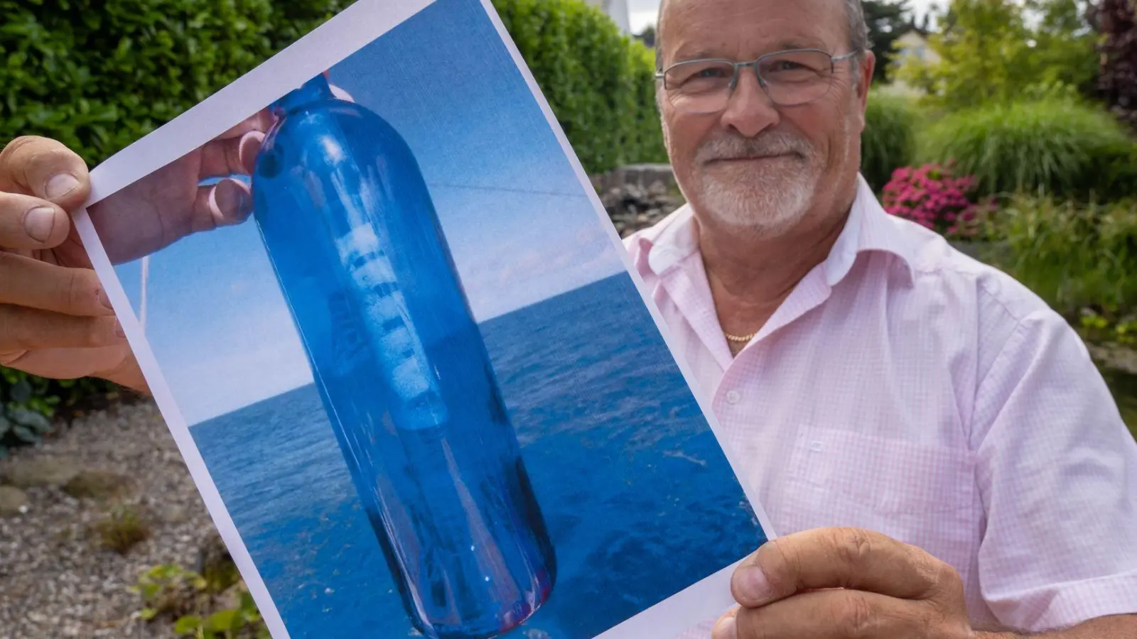 Jörg Wanke zeigt ein Foto seiner Flaschenpost. (Foto: Stefan Sauer/dpa)