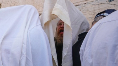 In Gebetsschals gehüllte jüdische Männer der Priesterkaste der Kohanim nehmen während des Pessachfestes an der Westmauer in Jerusalem an einer Segnungszeremonie teil. (Foto: Ohad Zwigenberg/AP/dpa)