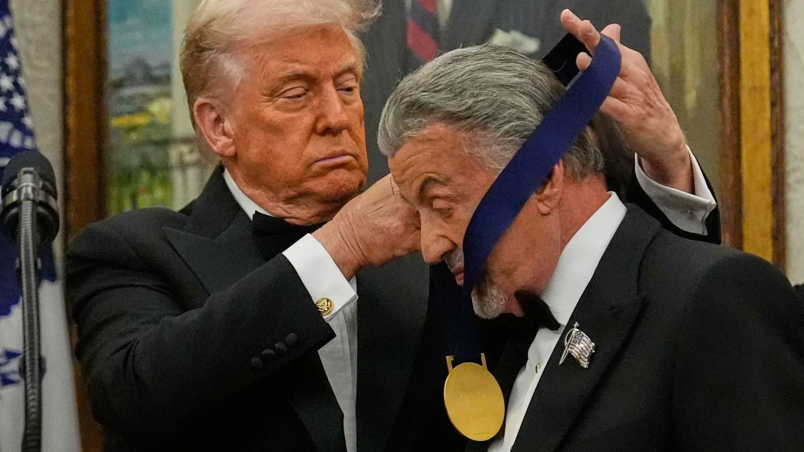 US-Präsident Donald Trump hängt der Actionfilm-Ikone Sylvester Stallone eine Medaille um.  (Foto: Julia Demaree Nikhinson/AP/dpa)