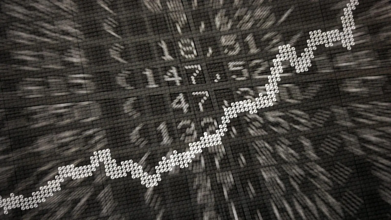 Die große Anzeige in der Börse zeigt die Dax-Kurve und verschiedene Börsenkurse: ETFs werden börsentäglich gehandelt. (Foto: Daniel Reinhardt/dpa)