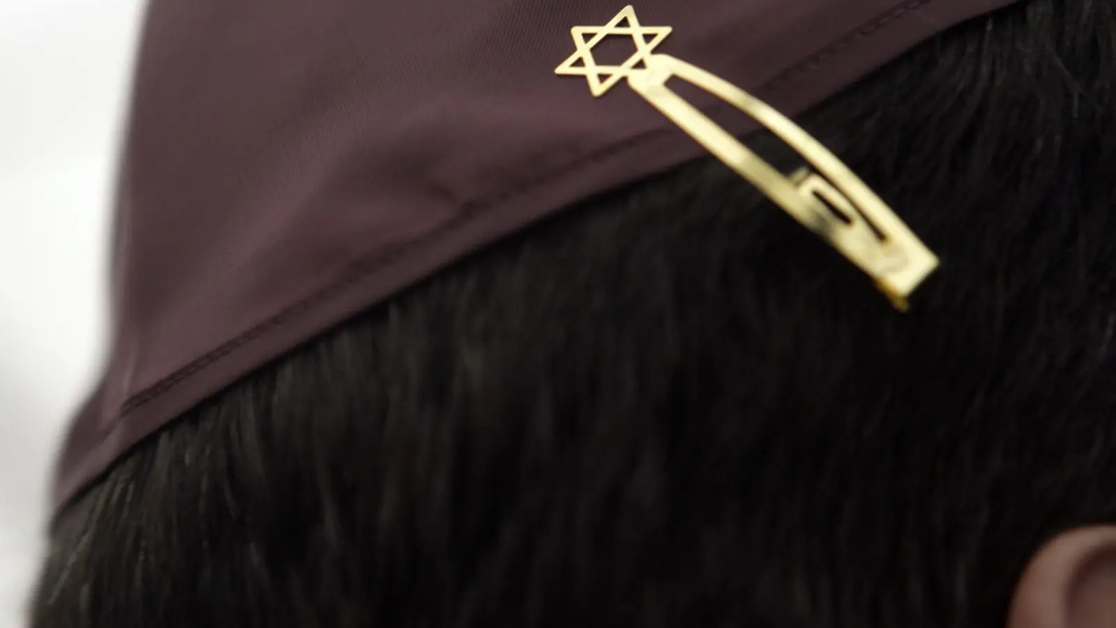 Ein Jude mit einer Kippa, die mit einer Davidstern-Klammer am Haar befestigt ist. (Foto: Fredrik von Erichsen/dpa)