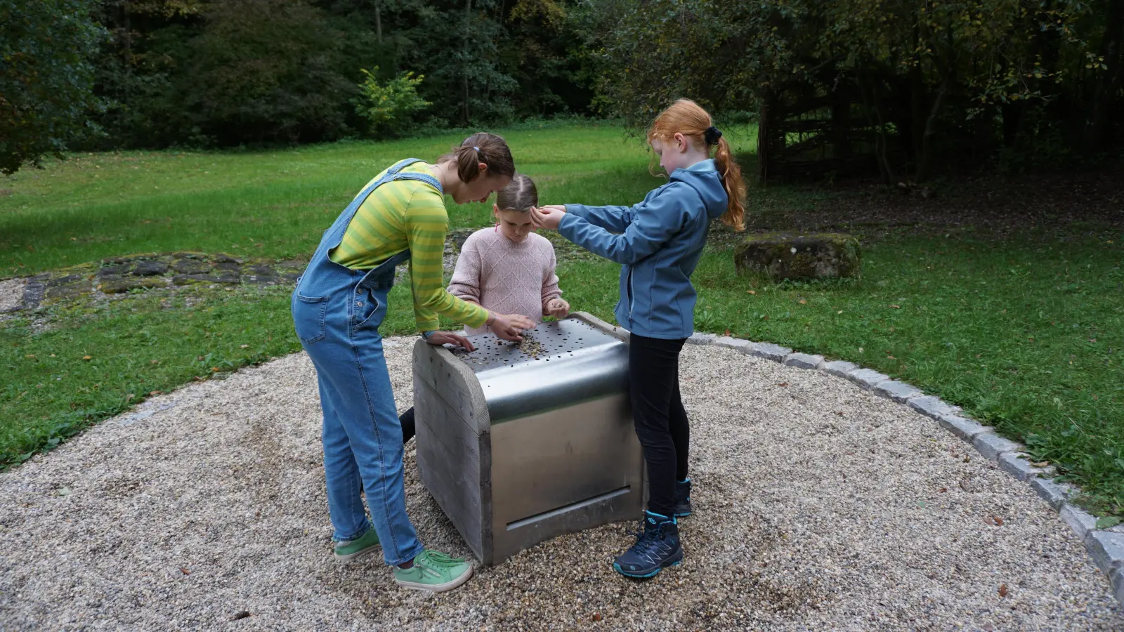 Beim Klimperkasten werden mit Steinchen Töne erzeugt. Paula Großmann (links) und die Schwestern Lea (Mitte) und Mara Oheimer sind ganz vertieft. (Foto: Andrea Walke)