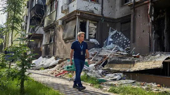 Ben Stiller, Schauspieler aus den USA und UNHCR-Botschafter, geht an zerstörten Wohnhäusern vorbei. Anlässlich des Weltflüchtlingstags rief der 56-jährige Schauspieler auch zur globalen Solidarität auf. (Foto: Andrew Mcconnell/UNHCR/AP/dpa)