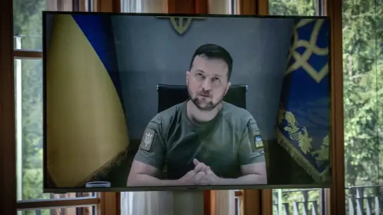 Wolodymyr Selenskyj ist per Videokonferenz zur Arbeitssitzung der Gipfelteilnehmer dazugeschaltet. (Foto: Michael Kappeler/dpa)