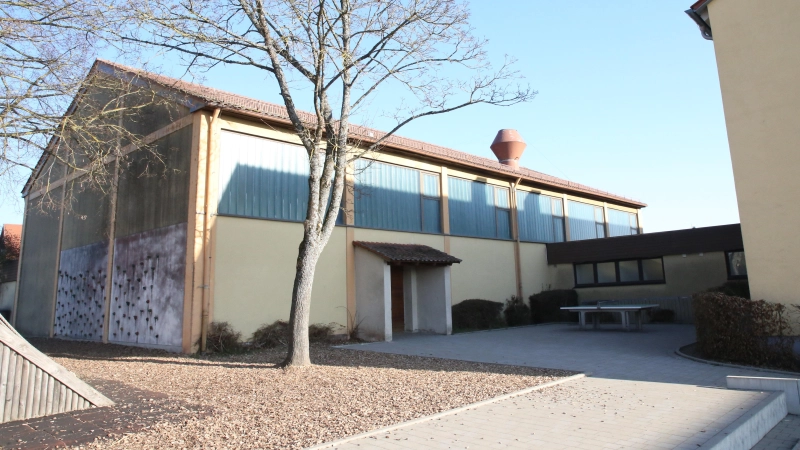 Die Mehrzweckhalle in Flachslanden soll generalsaniert und nach Süden hin erweitert werden. Dadurch wird der Pausenhof für die Grundschule Flachslanden ein weniger kleiner.  (Foto: Alexander Biernoth)