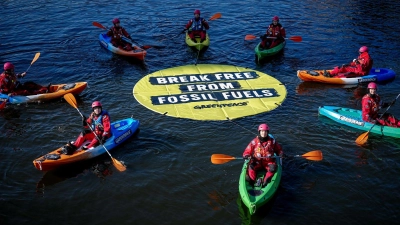 Greenpeace fordert bei einer Aktion am Veranstaltungsort die Abkehr von fossilen Energien. (Foto: Kay Nietfeld/dpa)