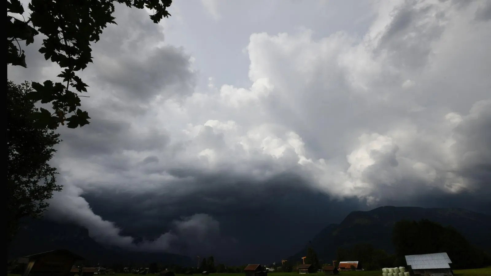 Dunkle Gewitterwolken ziehen über die Berge herauf. (Foto: Angelika Warmuth/dpa/Archivbild)