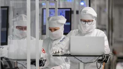 Mitarbeiter des Chipkonzerns Infineon arbeiten im Reinraum der Chipfabrik. (Foto: Robert Michael/dpa)