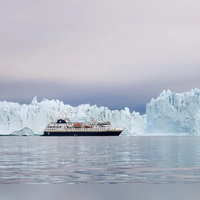 Vor so großen Eisbergen wirkt ein Schiff wie die „MS Spitsbergen“ ziemlich klein. (Foto: Verena Wolff/dpa-tmn)