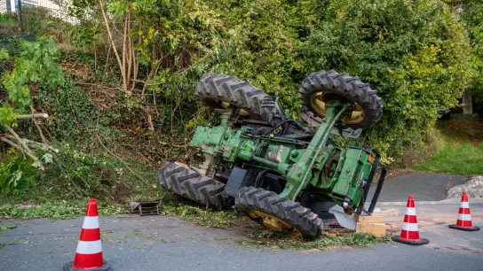 Ein Traktor liegt neben einer Böschung auf der Seite. (Foto: Bauernfeind/vifogra/dpa)