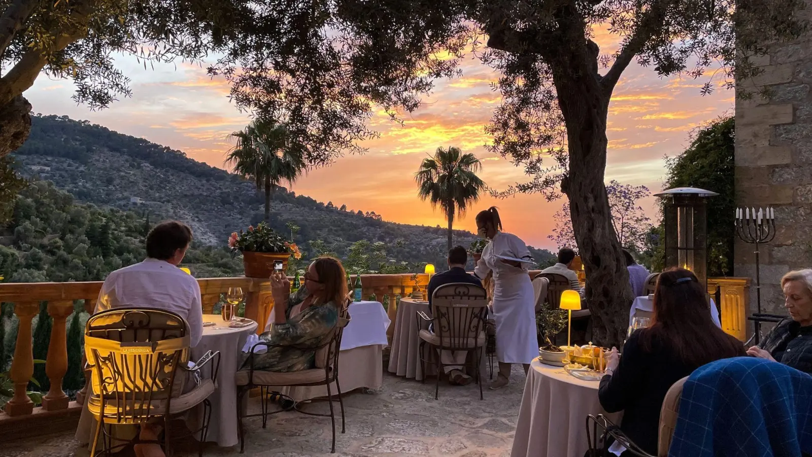 Auf der Terrasse des Restaurants El Olivo speist man unter Jahrhunderte alten Olivenbäumen und mit romantischen Blicken aufs Bergdorf Deià. (Foto: Manuel Meyer/dpa-tmn)