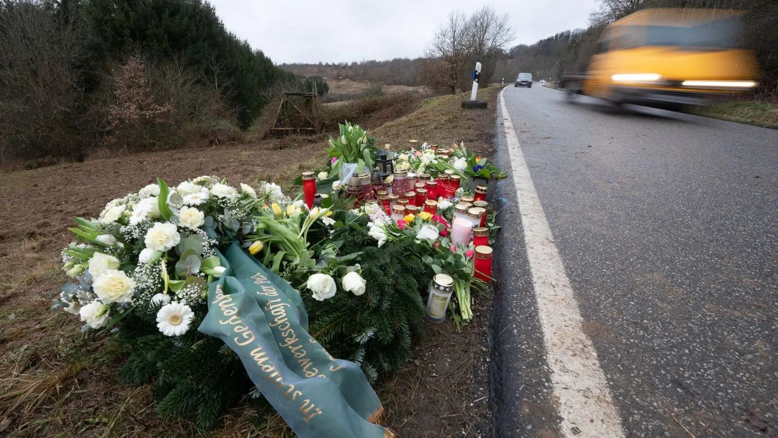 Blumen und Kerzen am Tatort, an dem Ende Januar 2022 bei Kusel zwei Polizeibeamte bei einer Verkehrskontrolle erschossen wurden. (Foto: Sebastian Gollnow/dpa)