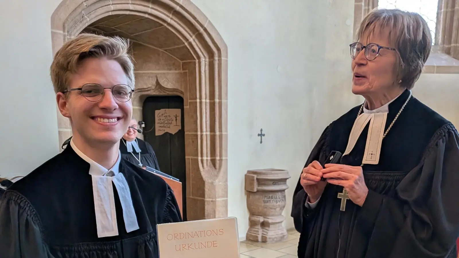 Pfarrer Samuel Rodrian (links) mit der von Regionalbischöfin Gisela Bornowski (rechts) verliehenen Ordinationsurkunde. (Foto: Friedrich Zinnecker)