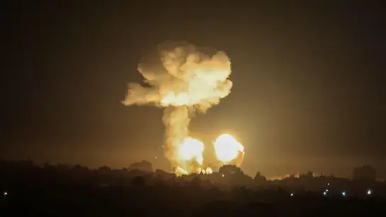 Ein Feuerball und eine Rauchwolke steigen während eines Luftangriffs über Gebäuden auf. (Foto: Abed Rahim Khatib/dpa)