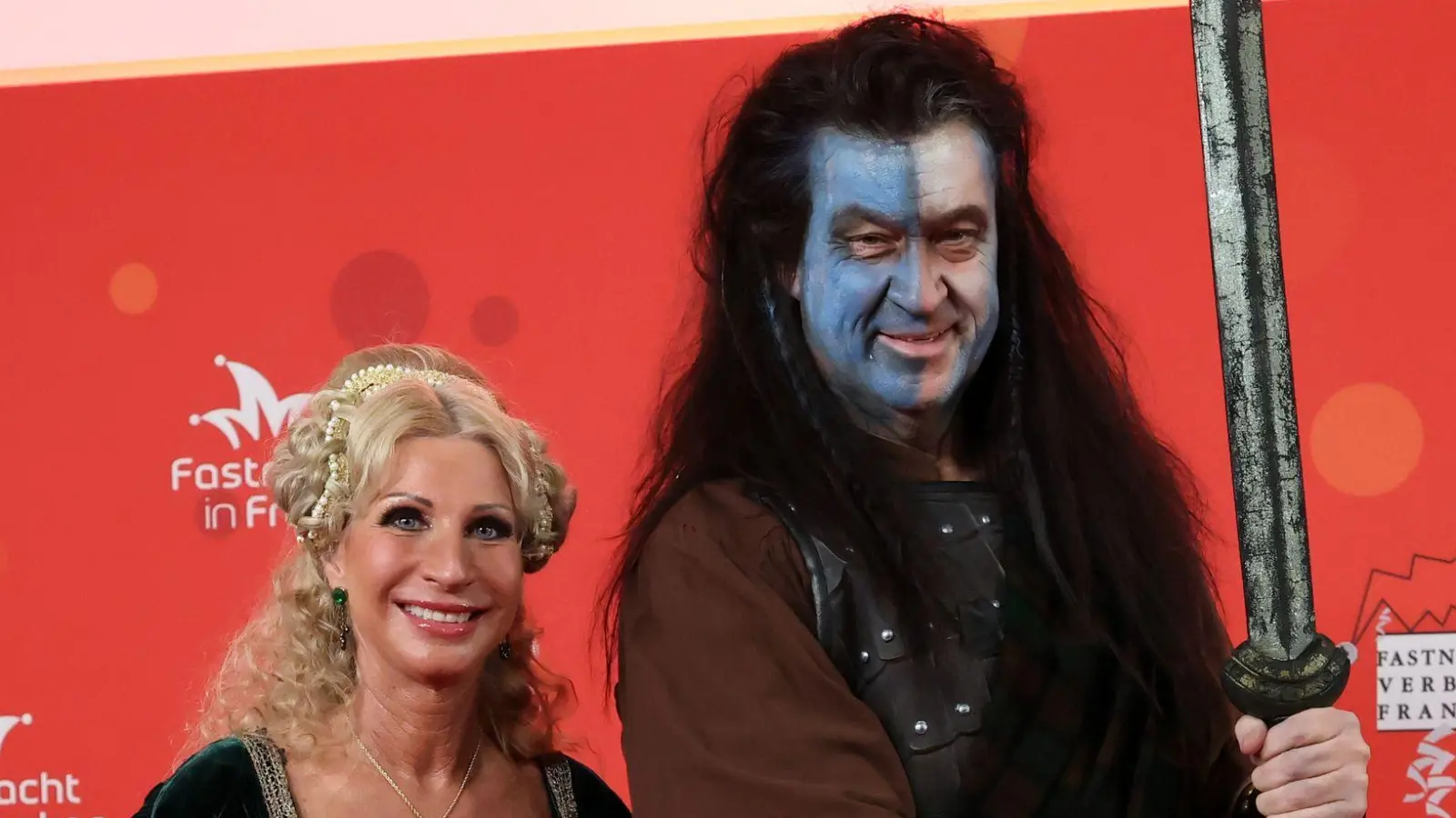 Bayerns Ministerpräsident Markus Söder und seine Frau Karin Baumüller-Söder zeigen sich vor Beginn der Prunksitzung „Fastnacht in Franken“ auf dem roten Teppich. (Foto: Daniel Löb/dpa)