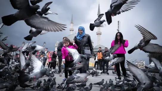 Menschen vergnügen sich beim Spiel mit Tauben auf dem Taksim-Platz in der türkischen Stadt Istanbul. (Foto: Shady Alassar/ZUMA Press Wire/dpa)