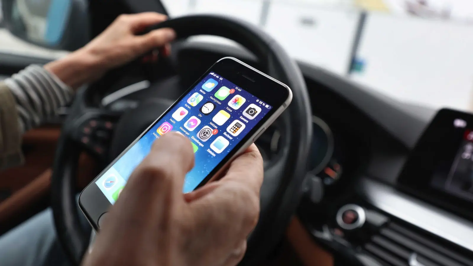 Sorgt für Ablenkung beim Fahren und dadurch immer wieder für Unfälle: das Smartphone am Steuer. (Illustration) (Foto: Karl-Josef Hildenbrand/dpa)