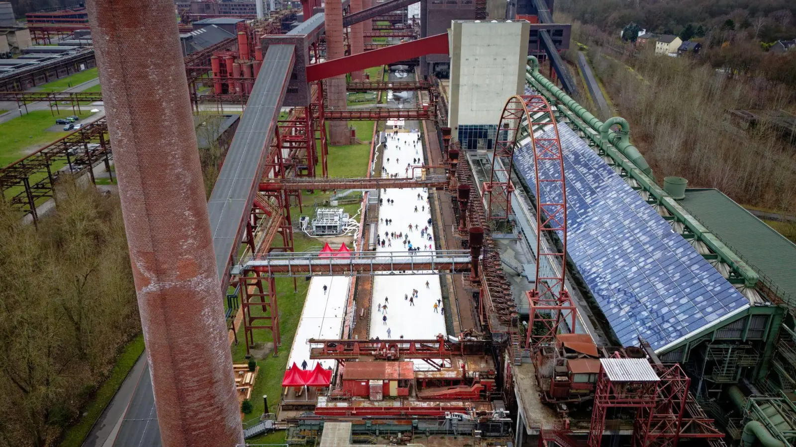 Menschen tummeln sich auf der Eisbahn in der Zeche Zollverein in Essen.  (Foto: Henning Kaiser/dpa)