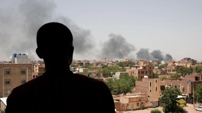 Ein Mann blickt auf die Stadt Khartum, wo schwarzer Rauch aufsteigt. Seit nun mehr vier Monaten bekämpfen sich die Konfliktparteien im Sudan. (Foto: Marwan Ali/AP)