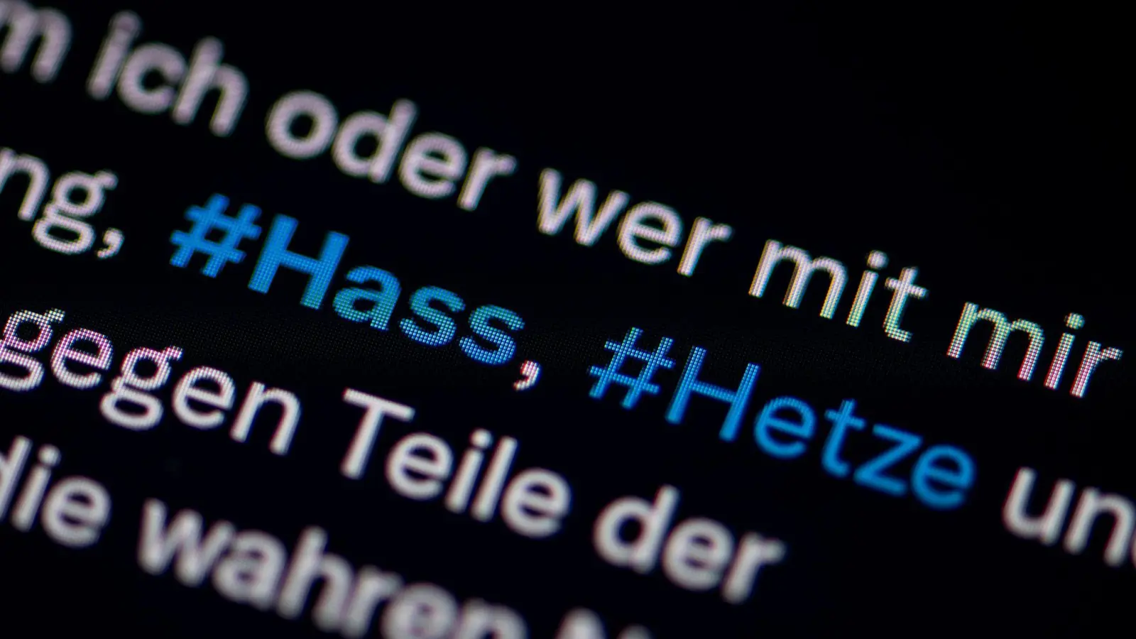 Auf dem Bildschirm eines Smartphones sieht man die Hashtags Hass und Hetze. (Foto: Fabian Sommer/dpa)