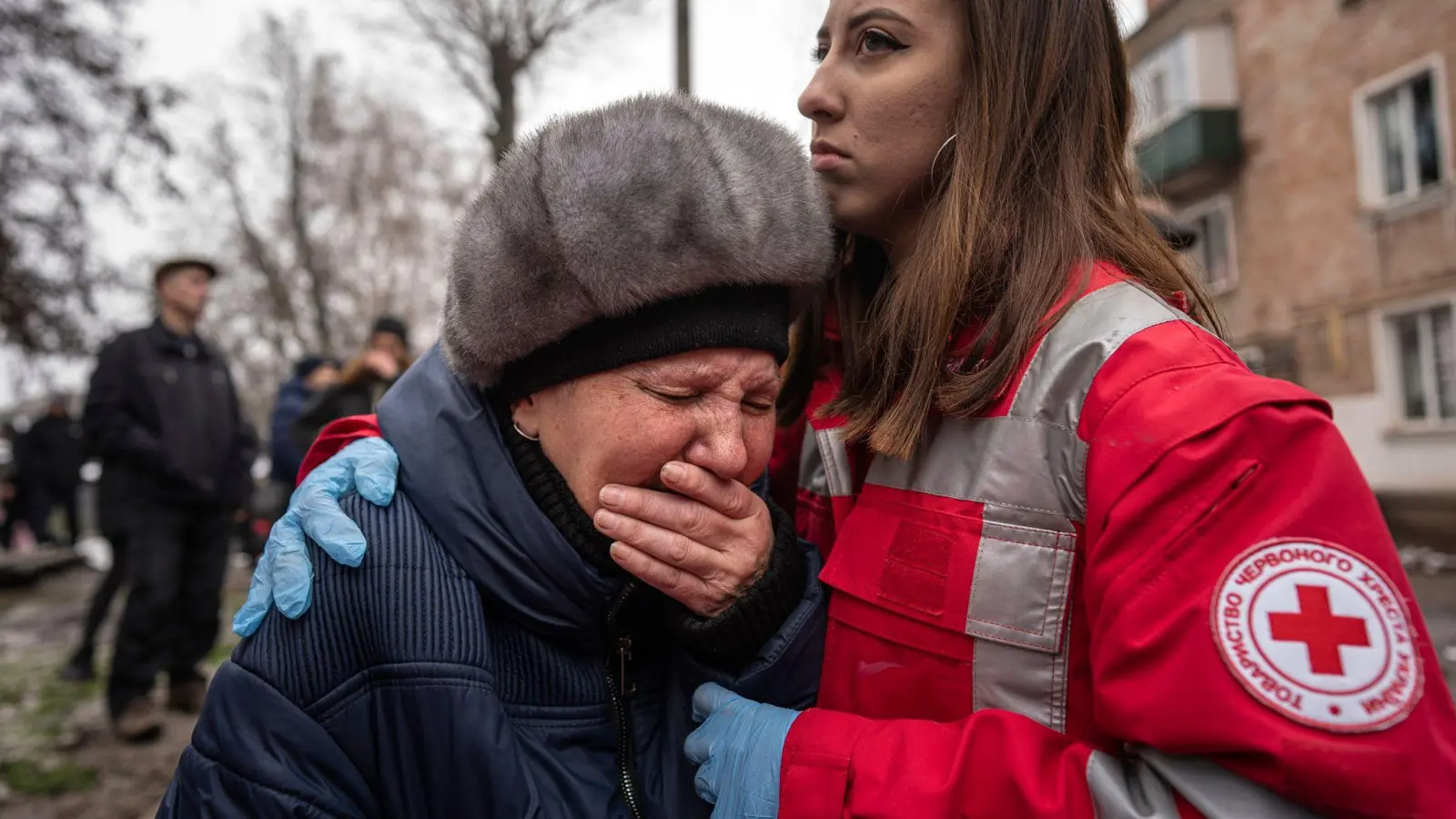 Eine Frau weint in den Armen einer Rettungskraft in der südostukrainischen Industriestadt Krywyj Rih. (Foto: Evgeniy Maloletka/AP/dpa)