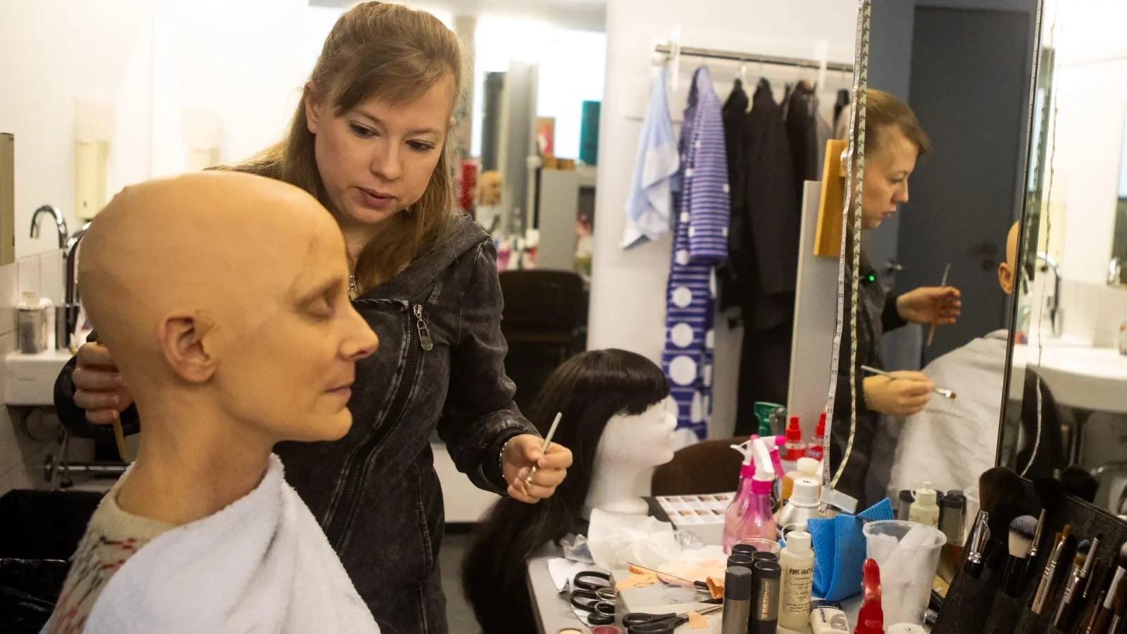 Maskenprobe für „Edward Gants Bravourstücke der Einsamkeit“: Die Schauspielerin Viola Neumann hat eine Glatze verpasst bekommen, ehe Maskenbildnerin Conny Maierhöfer zu schminken beginnt. (Foto: Evi Lemberger)