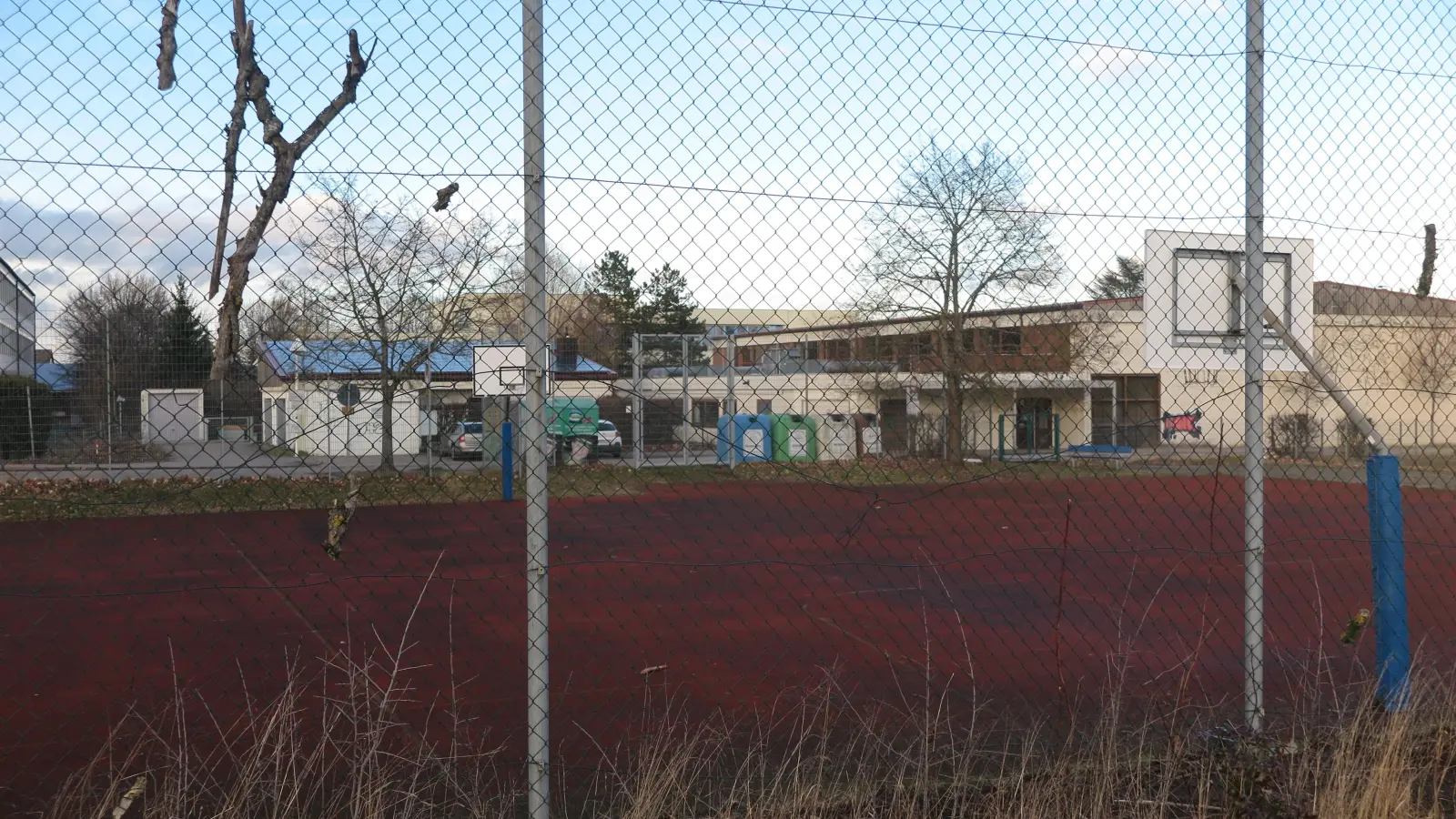 Ein paar im Zaun hängende Äste sind übriggeblieben von den Bäumen und Sträuchern, die im Süden des Sportgeländes für den Bau einer Containeranlage gerodet wurden. (Foto: Eckard Dürr)