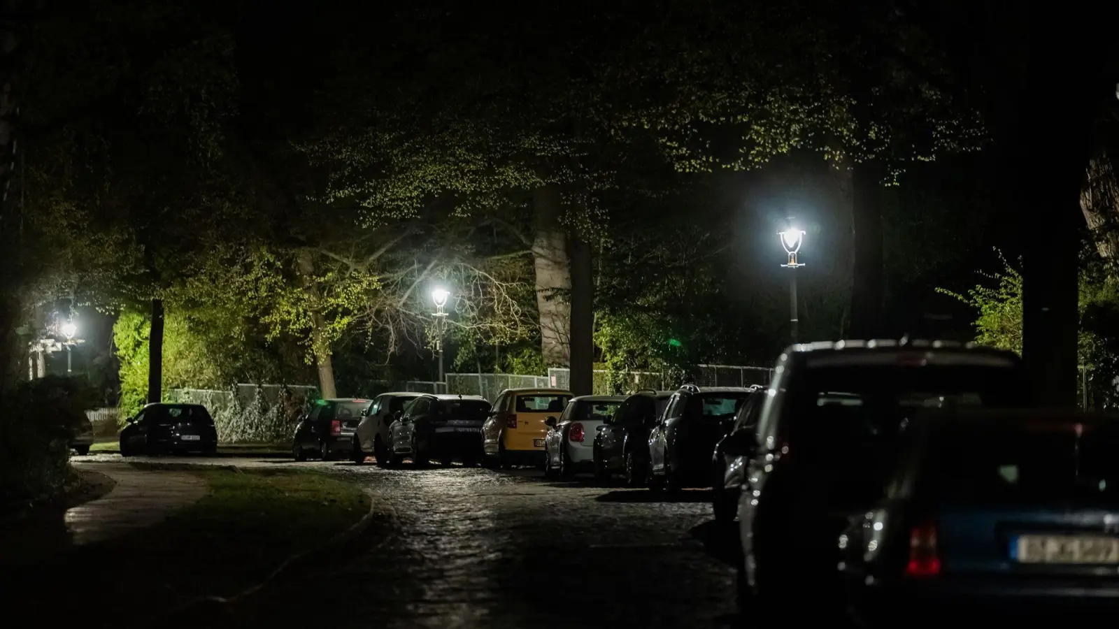 Der Kirchweg im Berliner Ortsteil Nikolassee ist bei einem Stromausfall weitgehend dunkel, da nur die Gaslaternen noch Licht spenden. (Foto: Christoph Soeder/dpa)