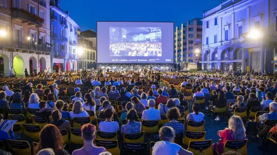 Besucher verfolgen eine Filmvorführung auf der Piazza Grande während des 74. Internationalen Filmfestivals (2021). Dieses Jahr wird ein rundes Jubiläum gefeiert. (Foto: Urs Flueeler/KEYSTONE/dpa)