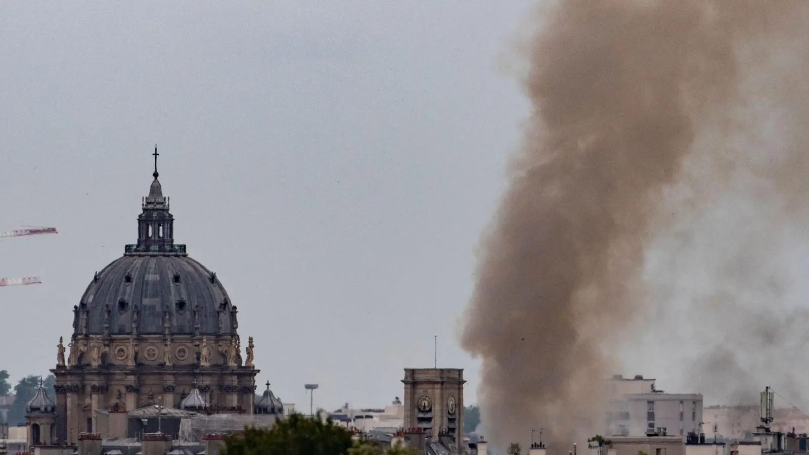 Rauch steigt aus einem Gebäude am Place Alphonse-Laveran in der Nähe des Doms des Val de Grace (l) in Paris auf. (Foto: Ian Langsdon/AFP/dpa)