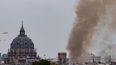 Rauch steigt aus einem Gebäude am Place Alphonse-Laveran in der Nähe des Doms des Val de Grace (l) in Paris auf. (Foto: Ian Langsdon/AFP/dpa)