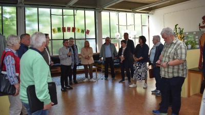 Alexander Knäulein, Leiter der Schule im Aischgrund (Bildmitte mit Mikrofon), stellte die von den Schülerinnen und Schüler der Stütz- und Förderklassen genutzten Räumlichkeiten vor. Diese stünden bei einem Neubau nicht mehr zur Verfügung stehen, was ihm Sorgen macht. (Foto: Ute Niephaus)