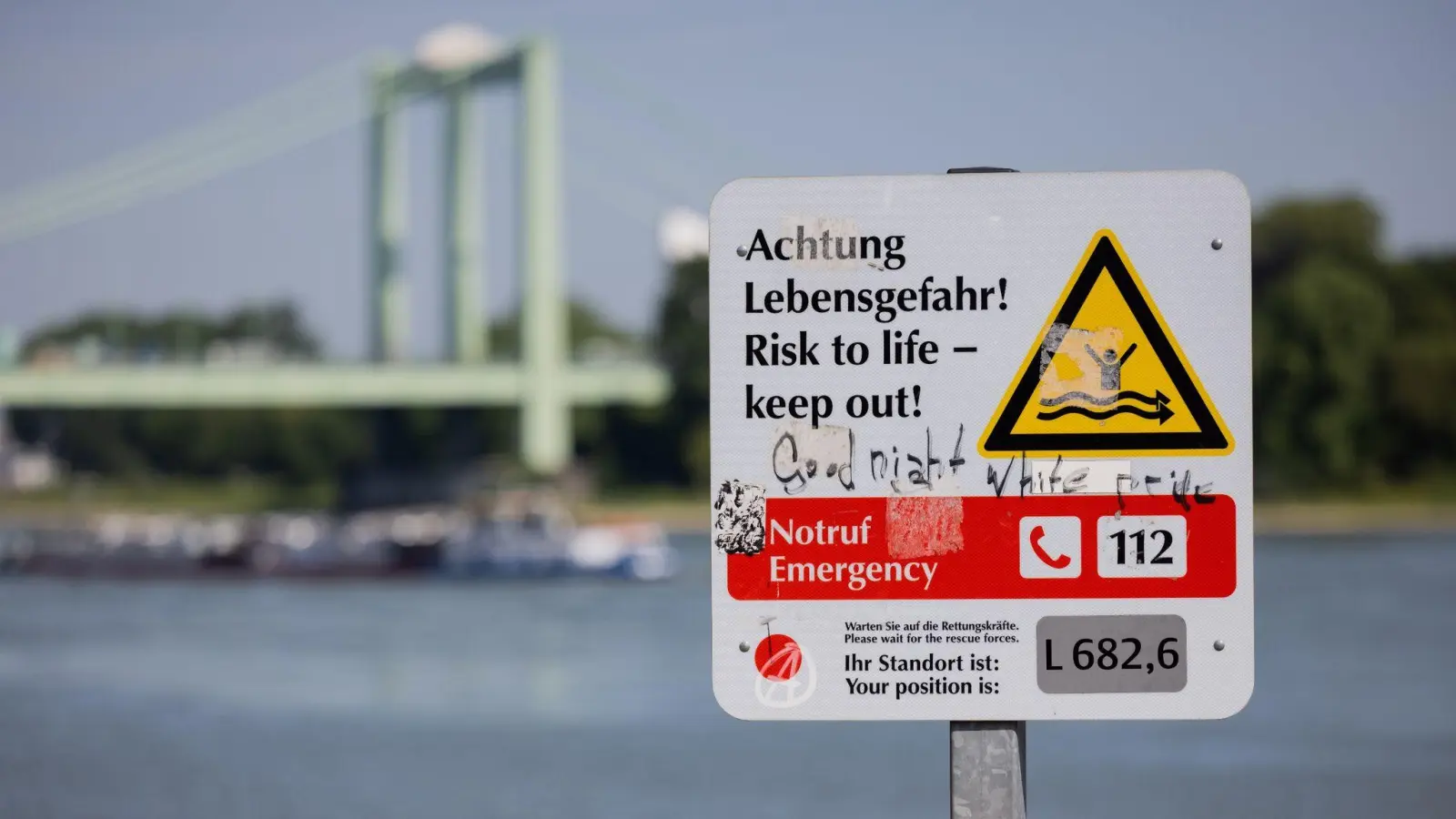 Ein Schild am Rheinufer weist auf die Gefahren beim Schwimmen im Fluss hin. (Foto: Rolf Vennenbernd/dpa)