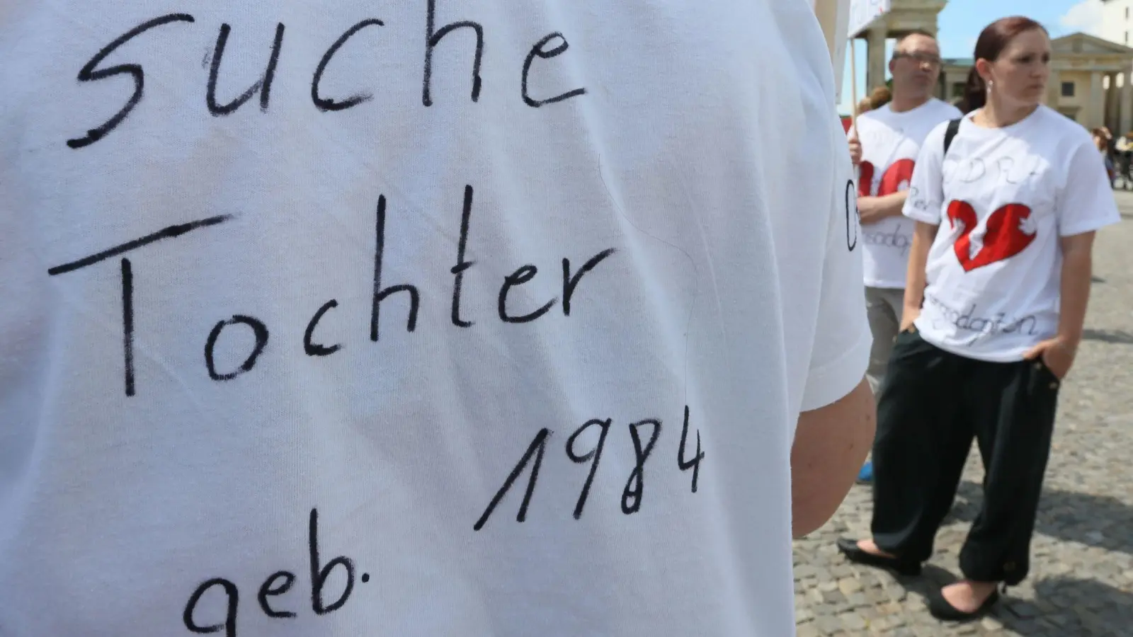 "Suche Tochter, geb. 1984" steht auf dem T-Shirt einer Frau bei einer Kundgebung. (Foto: Stephanie Pilick/dpa)