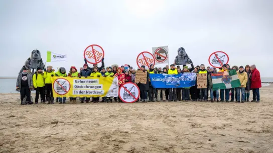 Umweltschützer und Insulaner demonstrieren am Weststrand von Borkum mit Bannern und Plakaten gegen die geplante Erdgasförderung. (Foto: Sina Schuldt/dpa)