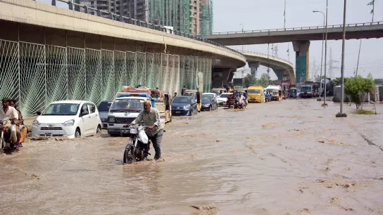 Motoradfahrer und Autos kämpfen sich durch eine überflutete Straße in Karachi. (Foto: PPI/ZUMA/dpa)