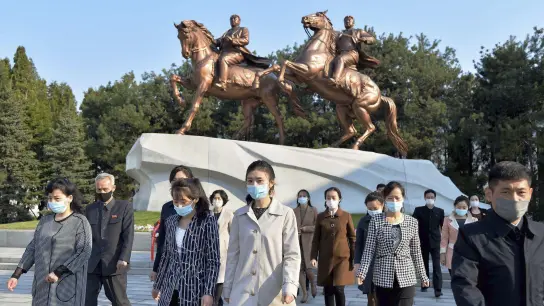 Menschen mit Mund-Nasen-Schutz besuchen im April das Mansudae-Kunststudio in Pjöngjang. Nordkorea hat seinen ersten Corona-Fall gemeldet. (Foto: -/kyodo/dpa)