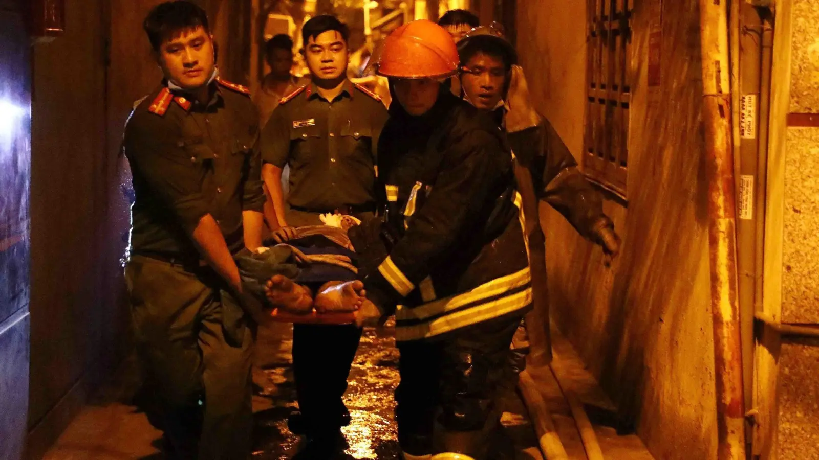 Rettungskräfte tragen eine Person aus einem brennenden Gebäude in der vietnamesischen Hauptstadt Hanoi. (Foto: Pham Trung Kien/VNA/AP/dpa)