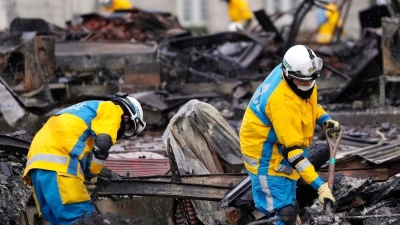 Polizeibeamte suchen nordwestlich von Tokio nach Opfern eines durch das Erdbeben verursachten Brandes. (Foto: Hiro Komae/AP)