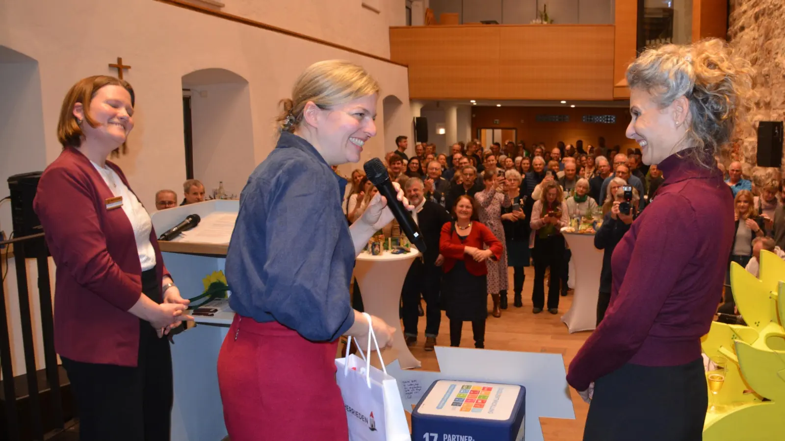 Bürgermeisterin Dorina Jechnerer (rechts) übergab beim Neujahrsempfang ein Gastgeschenk an Katharina Schulze (Mitte). Mit auf der Bühne stand die Kreisvorsitzende Franziska Wurzinger. (Foto: Peter Tippl [PETER TIPPL] )