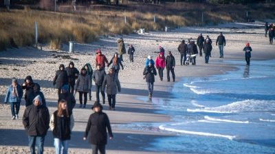 Touristen flanieren spazieren am Strand des Ostseebades auf der Insel Rügen. (Foto: Stefan Sauer/dpa)