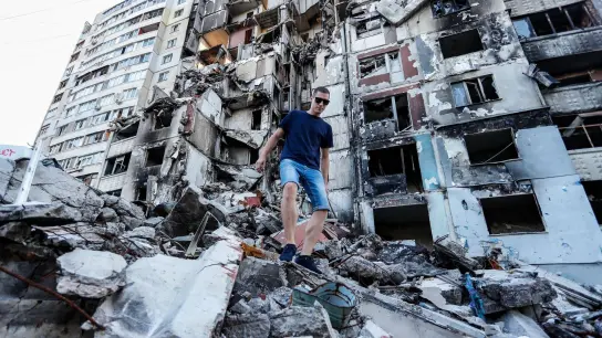 Ein Bewohner geht über die Trümmer eines eingestürzten Wohnhauses in Charkiw. (Foto: Daniel Ceng Shou-Yi/ZUMA Press Wire/dpa)