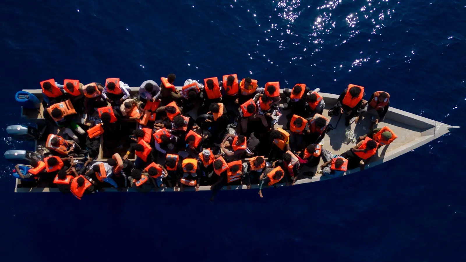 Menschen sitzen in einem Holzboot im Mittelmeer. Symbolbild (Foto: Joan Mateu Parra/AP/dpa)