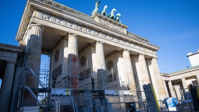 Auf einer Seite des Brandenburger Tors wird ein Baugerüst aufgebaut, um die Folgen der Farbattacke zu beseitigen. (Foto: Christophe Gateau/dpa)
