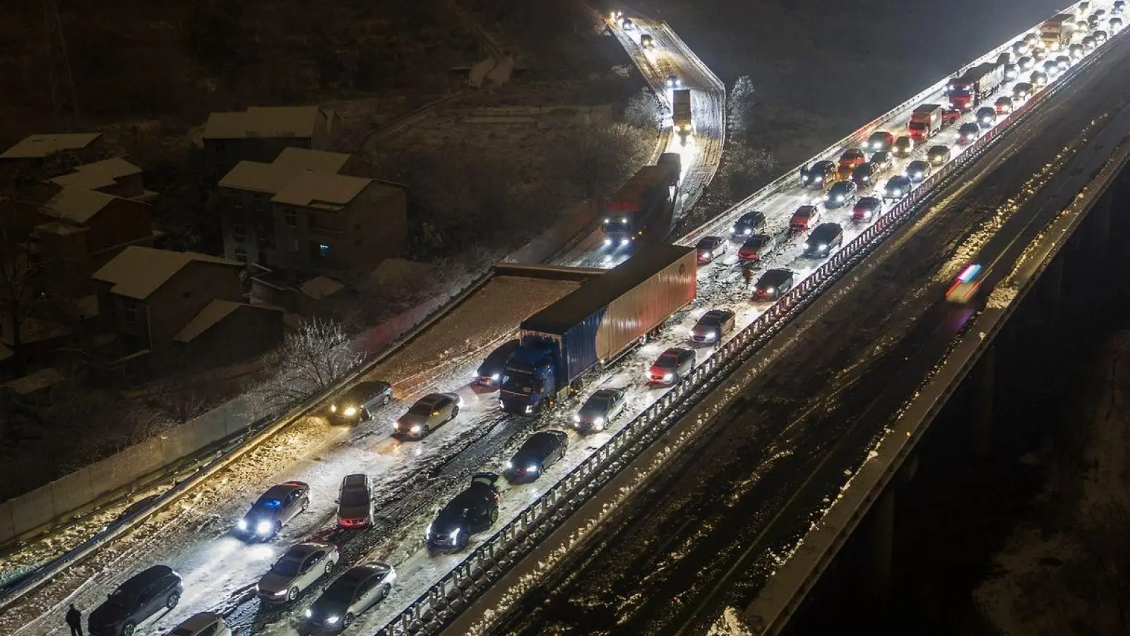 Am Stadtrand von Wuhan stecken die Fahrzeuge auf einer schneebedeckten Schnellstraße fest. (Foto: Chinatopix/AP/dpa)