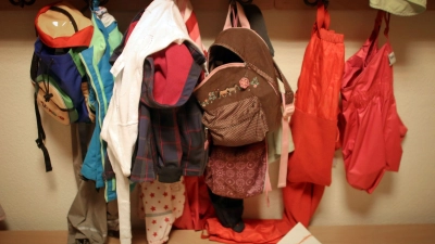 Jacken und Rucksäcke von Kindern in der Garderobe einer Betriebskita. (Foto: Fredrik Von Erichsen/dpa)