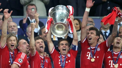 Fußball-Bundesligisten FC Bayern München feiern mit dem Pokal im Jahr 2013. (Foto: Friso Gentsch/dpa/Archivbild)